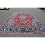 A good large Persian design carpet, red ground with floral decoration within a blue ground border