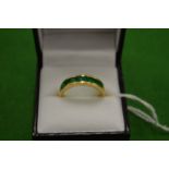 An 18ct gold ring set with 9 baguette cut treated emeralds size T.