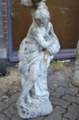 A composite garden ornament modelled as a classical standing female semi nude holding an urn.