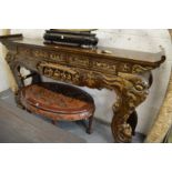A large Chinese carved and gilded scroll end altar table.