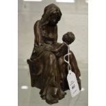 A small bronze sculpture of a seated mother and child.