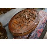 A Chinese carved wood oval coffee table.