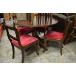 A mahogany circular pedestal dining table and four chairs.