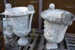 A large pair of carved marble twin handled urns on circular bases (af).