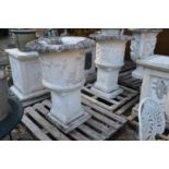 A pair of carved white marble classical style urns on pedestal bases.