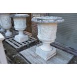 A good large pair of carved marble urns on square bases.