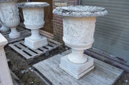 A good large pair of carved marble urns on square bases.