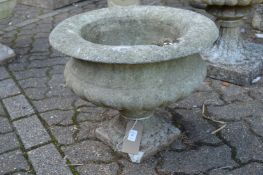 A small composite circular pedestal garden planter.