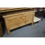 A pine coffer and an upholstered stool.