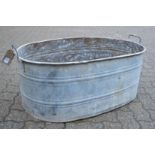 A large galvanised twin handled oval garden planter.