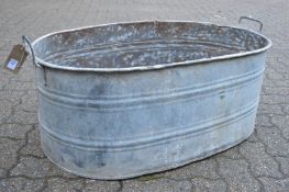 A large galvanised twin handled oval garden planter.