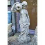 A good large composite garden statue modelled as a classical female semi nude with an urn on her