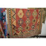 A flat weave Kilim carpet, red ground with stylised decoration 240cm x 146cm.