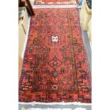 A Persian design carpet, crimson ground with a central medallion 190cm x 100cm.