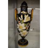 A floral painted twin handled vase and cover.