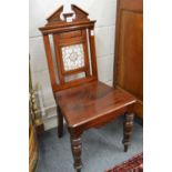 A Victorian mahogany hall chair with tile inset back.