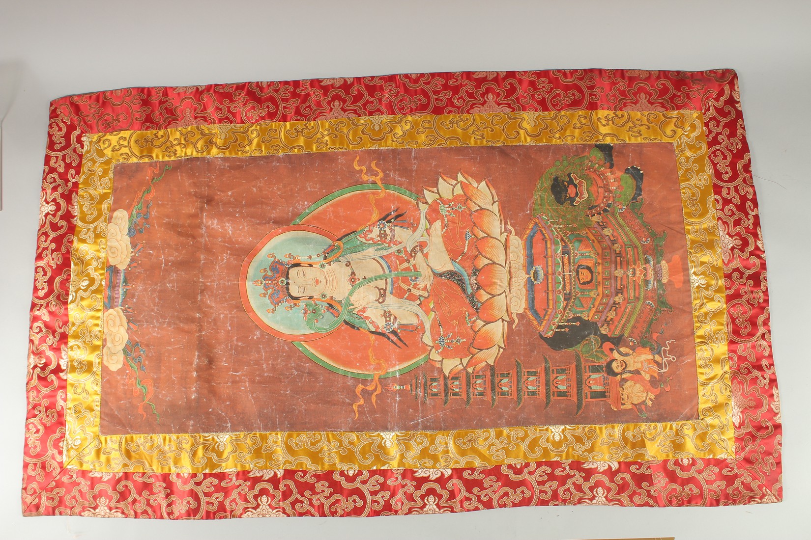 A TIBETAN THANGKA MOUNTED ON SILK.