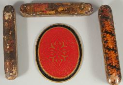THREE PERSIAN QAJAR LACQUERED QALAMDANS PEN BOXES, together with another oval panel, (4).