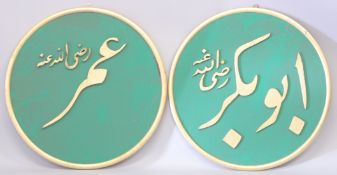 A LARGE PAIR OF ISLAMIC GILDED WOODEN CALLIGRAPHIC PANELS, each 71cm diameter.
