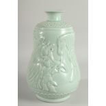A CHINESE CELADON GLAZE PORCELAIN VASE, the body carved with figures and a horse, 33cm high.