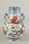 A CHINESE BLUE, WHITE AND UNDERGLAZE RED PORCELAIN TWIN HANDLE HU VASE, decorated with dragon and