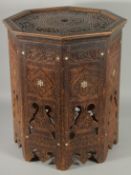 A SYRIAN OCTAGONAL WOODEN TABLE, with mother of pearl inlay to the sides and carved panels of