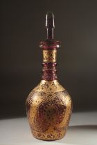 A LARGE BOHEMIAN GLASS BOTTLE AND STOPPER, the body with decorative gilded motifs, 48cm high.