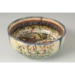 A VINTAGE KHOROSAN STYLE GLAZED POTTERY BOWL, painted with a figure and calligraphy, 21cm diameter.