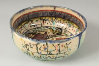 A VINTAGE KHOROSAN STYLE GLAZED POTTERY BOWL, painted with a figure and calligraphy, 21cm diameter.