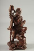 A CHINESE CARVED HARDWOOD FIGURE, 25.5cm high.