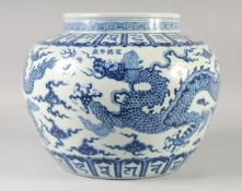 A LARGE CHINESE BLUE AND WHITE PORCELAIN JARDINIERE, painted with dragons and bands of characters,