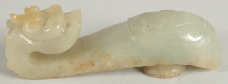 A 19TH CENTURY CHINESE CARVED JADE BELT HOOK, in the form of a dragon, 8.5cm long.