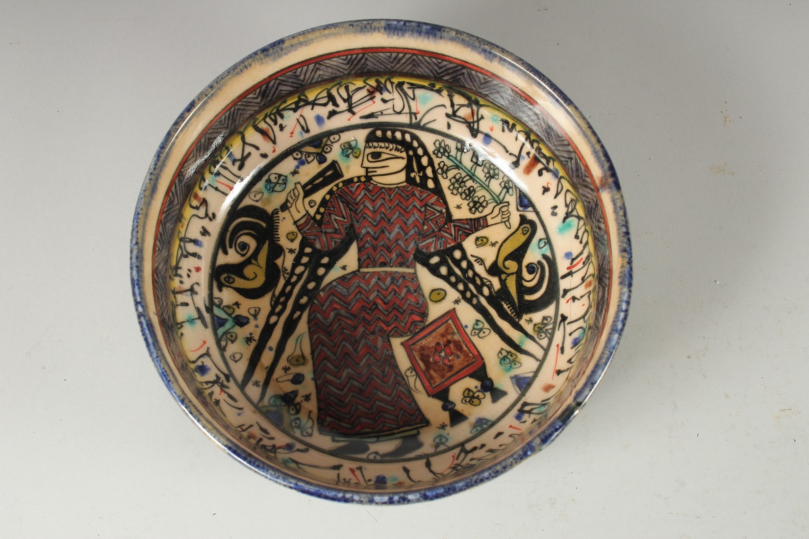 A VINTAGE KHOROSAN STYLE GLAZED POTTERY BOWL, painted with a figure and calligraphy, 21cm diameter. - Image 2 of 3