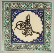 A TURKISH KUTAHYA GLAZED POTTERY TILE, with central tughra, 15cm square.