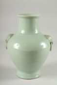 A CHINESE CELADON GLAZED VASE, with moulded drop ring handles, the base with character mark, 25.