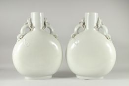 A VERY LARGE PAIR BLANC-DE-CHINE TYPE MOON FLASK VASES, with moulded dragon handles, 47.5cm high.