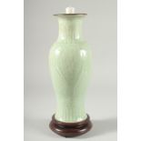 A CHINESE CELADON GLAZE PORCELAIN VASE, mounted as a lamp to a wooden base, 34cm high.