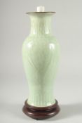 A CHINESE CELADON GLAZE PORCELAIN VASE, mounted as a lamp to a wooden base, 34cm high.
