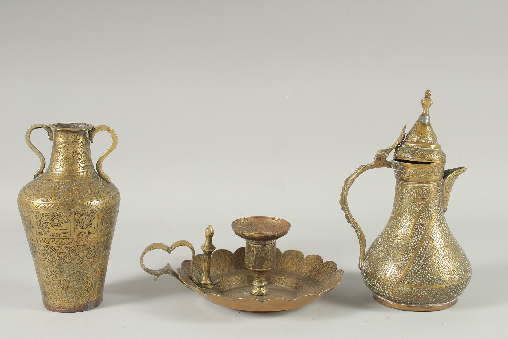 THREE 19TH CENTURY IRANIAN ENGRAVED BRASS PIECES; comprising a twin handle vase / vessel with