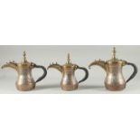 A FINE SET OF THREE EARLY 20TH CENTURY CAIROWARE ARAB SILVER AND COPPER INLAID BRASS COFFEE POTS