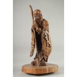 A VERY LARGE AND FINE WOOD CARVING OF SHAO LOU, mounted to a natural tree trunk base, the figure