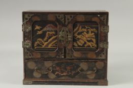 A JAPANESE LACQUERED WOOD JEWELLERY CABINET, the doors with gilt decorated panels depicting birds
