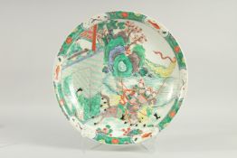 A LARGE CHINESE FAMILLE VERTE PORCELAIN DISH, painted with figures on horseback, 42.5cm diameter.
