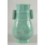 A CHINESE TURQUOISE GLAZED TWIN HANDLED POTTERY VASE. 10ins high.