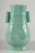 A CHINESE TURQUOISE GLAZED TWIN HANDLED POTTERY VASE. 10ins high.