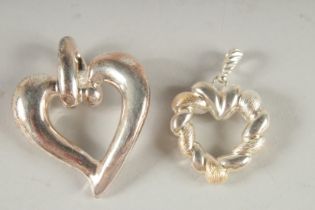 TWO SILVER HEART SHAPED PENDANTS.