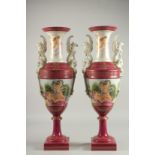 A TALL PAIR OF TAPERING SEVRES DESIGN TWO HANDLED VASES with classical scenes. 24ins high.