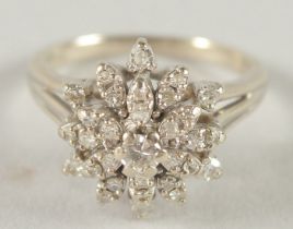 A 14CT WHITE GOLD DIAMOND CLUSTER RING.