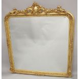 A LARGE GILTWOOD OVER MANTLE MIRROR with scrolls and cupids. 5ft 6ins high, 4ft 8ins wide