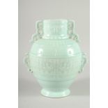 A CHINESE PALE TURQUOISE GROUND VASE with pierced handles and moulded decoration. 11ins high